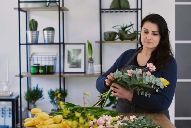 Hermosa joven florista hace un ramo