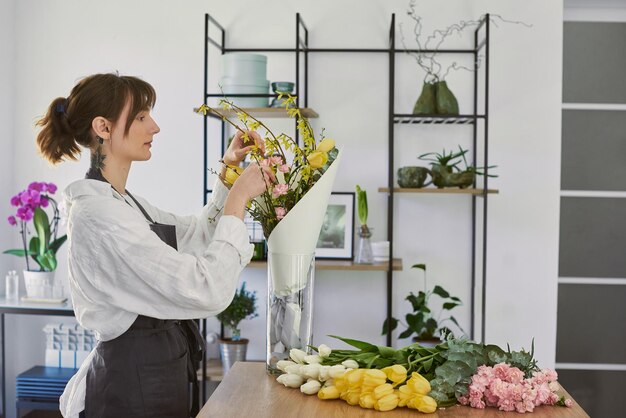 Hermosa joven florista hace un ramo