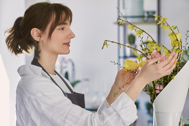 Hermosa joven florista hace un ramo