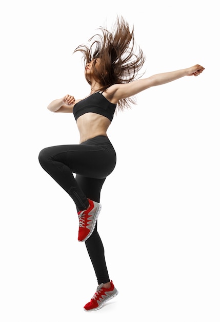 Foto hermosa joven en forma bailarina moderna dama bailando con su largo cabello volando