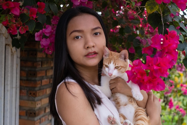 Hermosa joven con un gato afuera