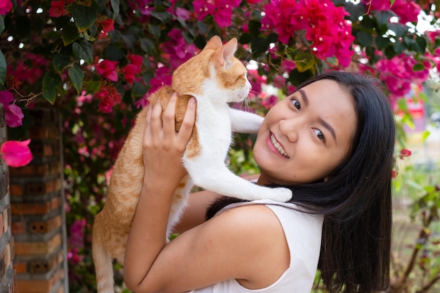 Hermosa joven con un gato afuera