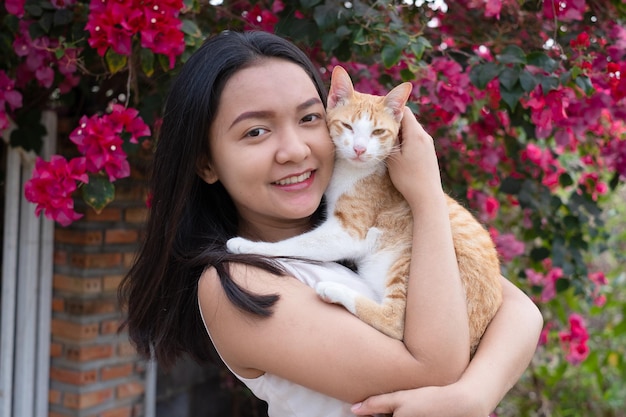 Hermosa joven con un gato afuera