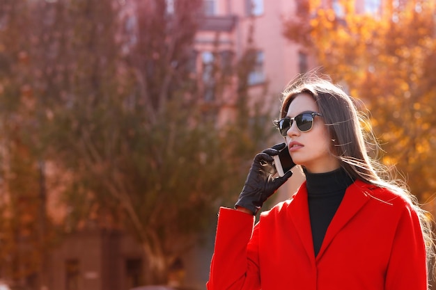 Hermosa joven hablando por teléfono móvil al aire libre