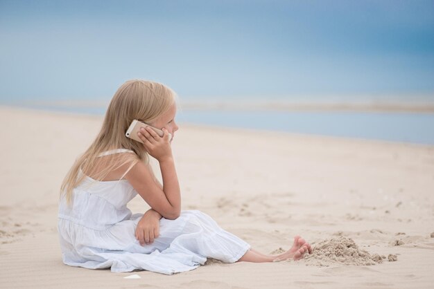 Foto hermosa joven hablando por teléfono en la playa