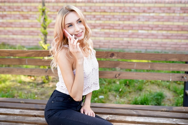 Hermosa joven hablando por teléfono y sonriendo