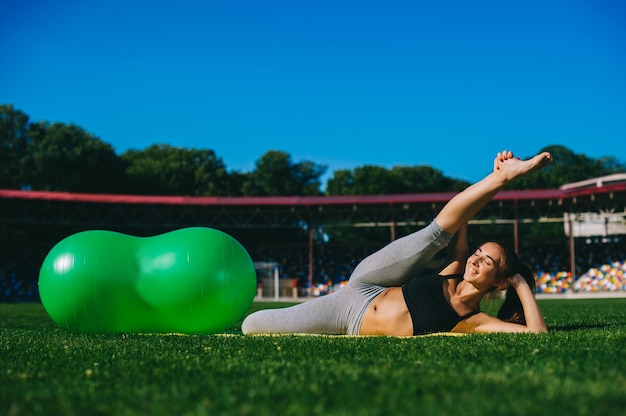 Hermosa joven haciendo ejercicios con fitball