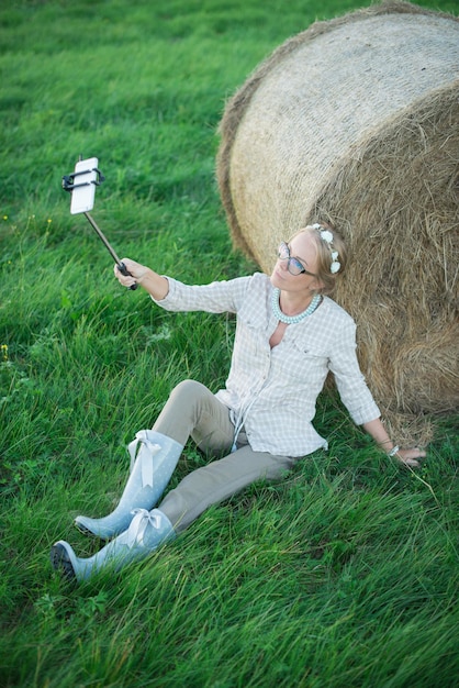 Hermosa joven haciendo un selfie en la hierba en el prado