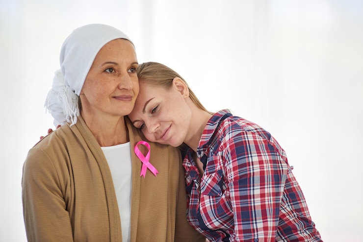 Foto hermosa joven hija se sienta junto a la madre que lucha contra el cáncer para apoyarla en la cama del hospital