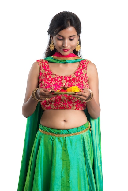 Hermosa joven india sosteniendo pooja thali o realizando adoración