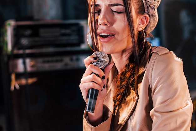 Hermosa joven intérprete femenina ensayando en un estudio de grabación