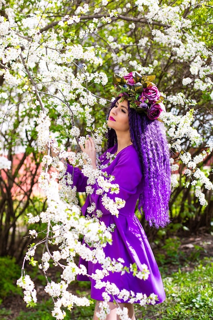 Foto hermosa joven en el jardín de los cerezos en flor