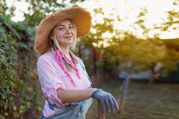 Hermosa joven jardinería afuera en la naturaleza de verano