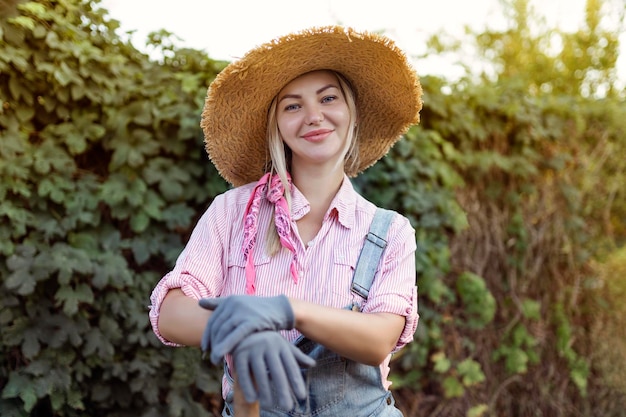 Hermosa joven jardinería afuera en la naturaleza de verano