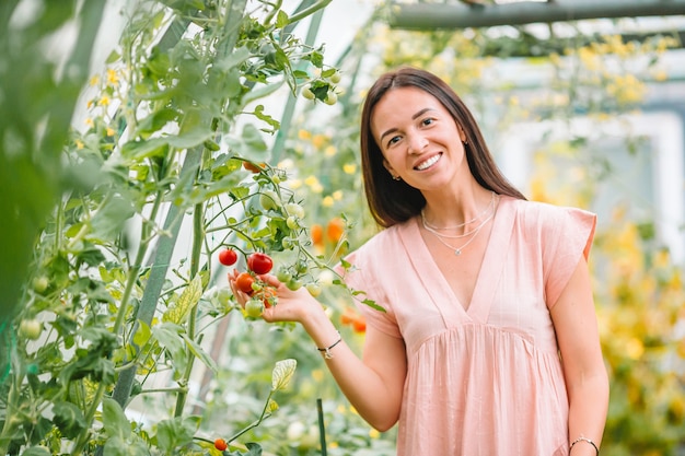 Hermosa joven jardinería en invernadero