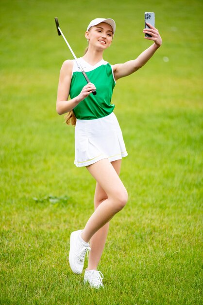 Hermosa joven jugando al golf en la hierba verde