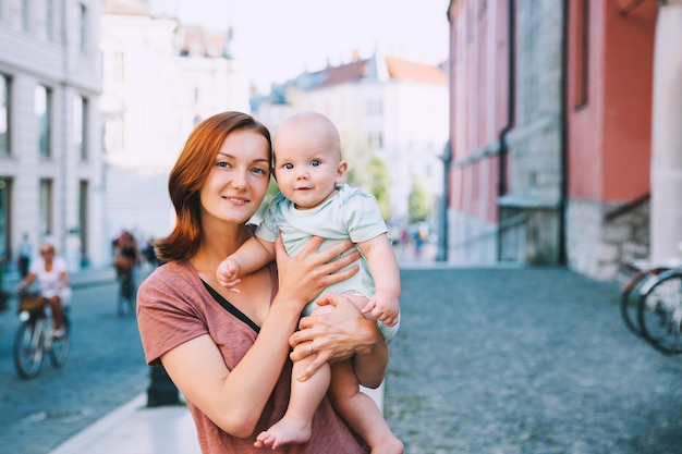 Foto hermosa joven madre con un bebé pasa tiempo en el casco antiguo de ljubljana eslovenia europa