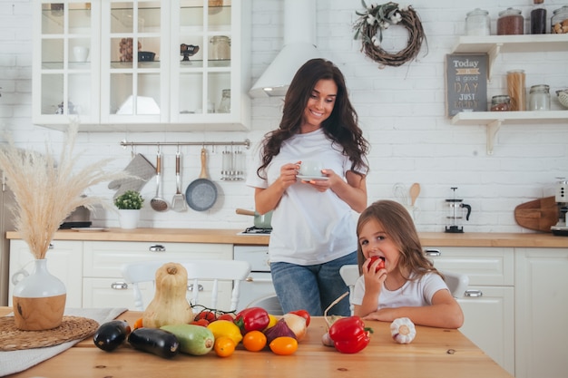 Hermosa joven madre e hija cocinando juntos