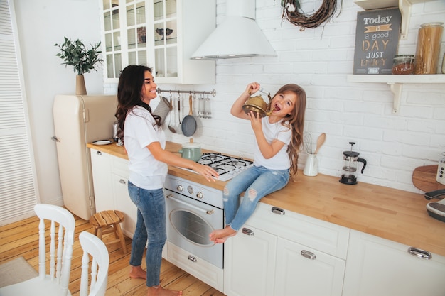 Hermosa joven madre e hija cocinando juntos