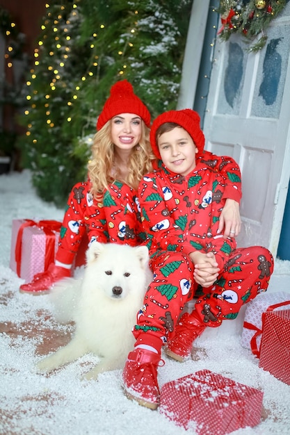 Hermosa joven madre e hijo en un traje de enano de Navidad en el fondo de adornos navideños.