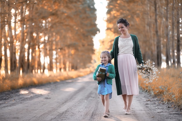 Foto hermosa joven madre con hija caminando por una carretera