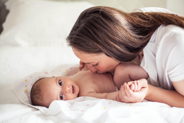 Hermosa joven madre sostiene a un bebé