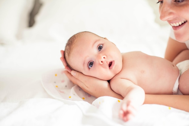 Hermosa joven madre sostiene a un bebé