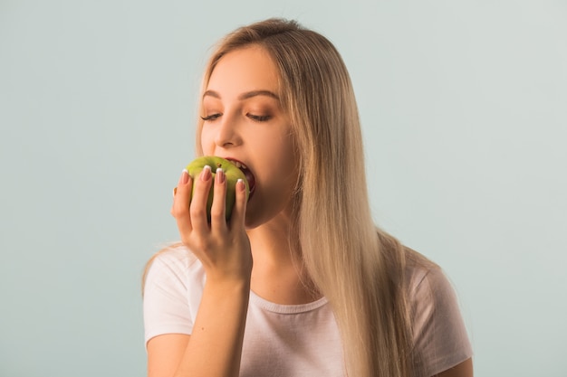 hermosa joven con una manzana verde en sus manos