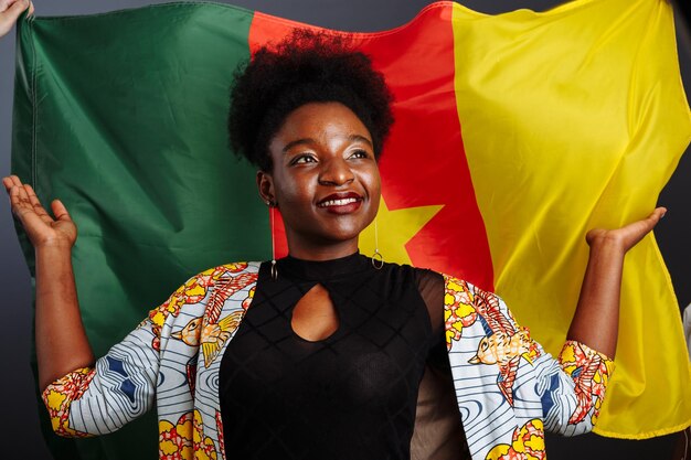 Foto hermosa joven modelo de moda africana con bandera de camerún en vestido tradicional