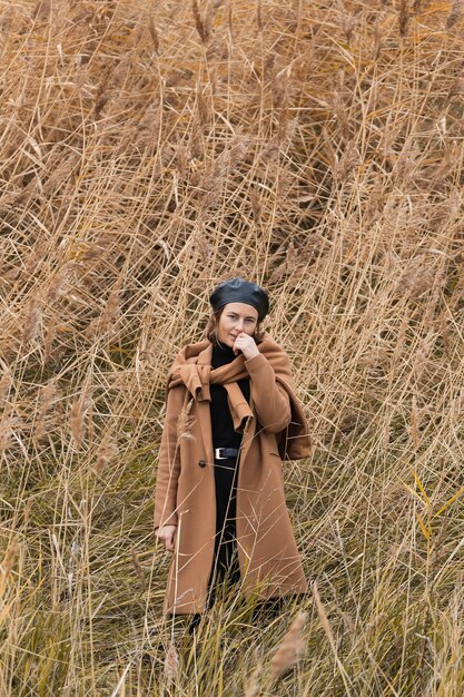 Hermosa joven modelo en ropa de abrigo en campo