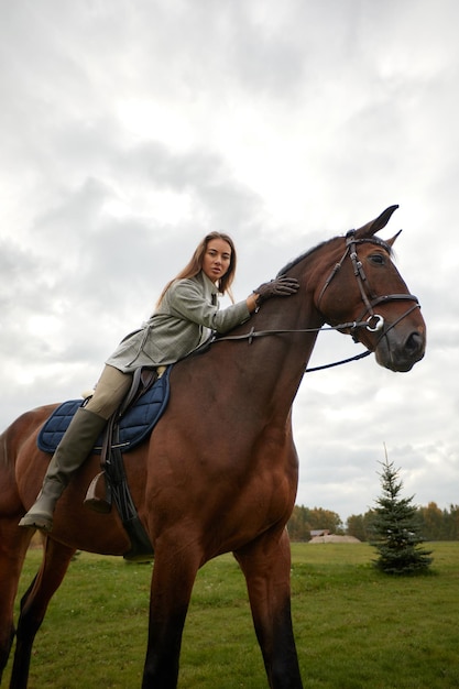 Hermosa joven montando un caballo en el campo De lado a la cámara Movimiento de alegría de libertad