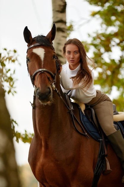 Hermosa joven montando un caballo en el campo De lado a la cámara Movimiento de alegría de libertad