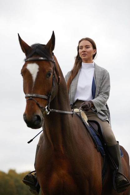 Hermosa joven montando un caballo en el campo De lado a la cámara Movimiento de alegría de libertad