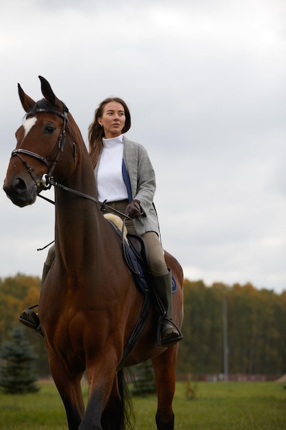 Hermosa joven montando un caballo en el campo De lado a la cámara Movimiento de alegría de libertad