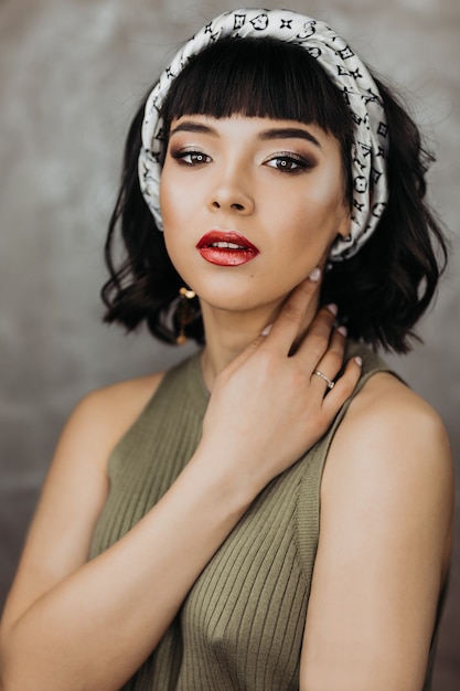 Hermosa joven morena de piel clara con hermoso maquillaje y labios rojos. Retrato de moda de belleza modelo.