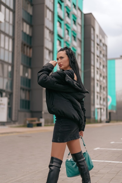 Hermosa joven morena vestida y posando en la calle.