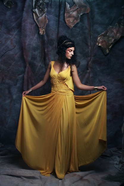 Hermosa joven morena con vestido de noche amarillo