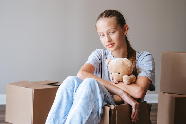 Hermosa joven mudándose a una casa nueva con cajas de cartón