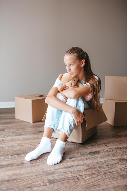 Hermosa joven mudándose a una casa nueva con cajas de cartón