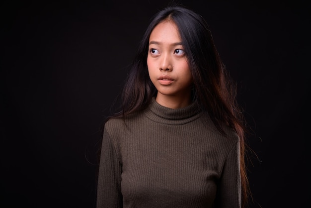 Hermosa joven mujer asiática vistiendo un suéter de cuello alto