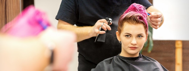 Hermosa joven mujer caucásica de pelo rosa en la peluquería moderna