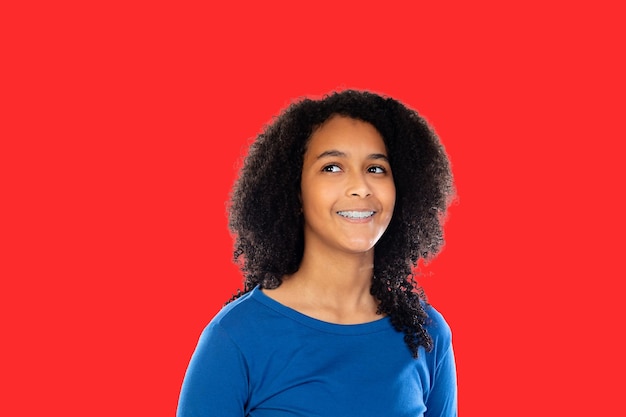 Hermosa joven mujer feliz primer plano retrato de estudio Sonriente linda estudiante alegre chica aislada sobre fondo rojo