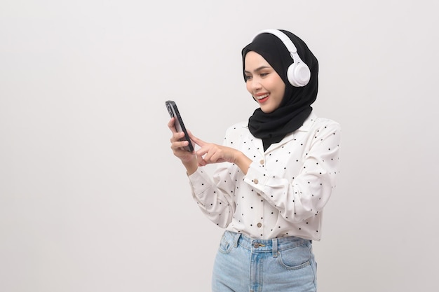 Hermosa joven mujer musulmana con auriculares sobre fondo blanco