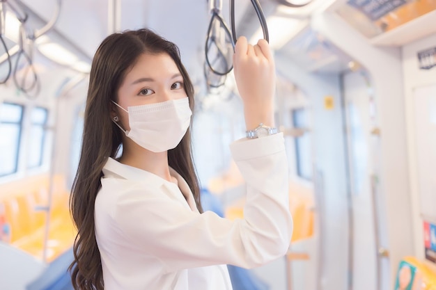 Hermosa joven mujer de negocios profesional asiática pasajera con máscara de protección de higiene médica.