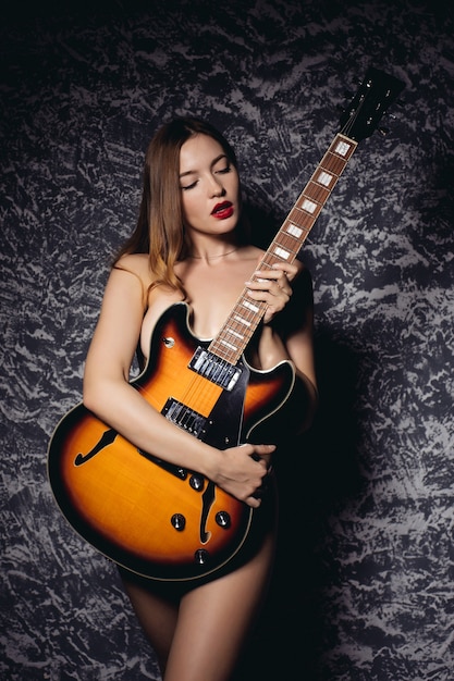 Hermosa joven mujer sexy con guitarra. Chica musical