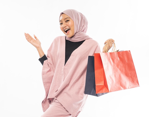 Hermosa joven musulmana feliz sosteniendo una bolsa de compras