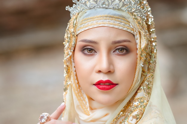 Hermosa joven musulmana con hijab dorado