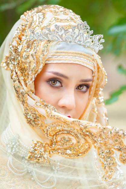 Hermosa joven musulmana con hijab dorado