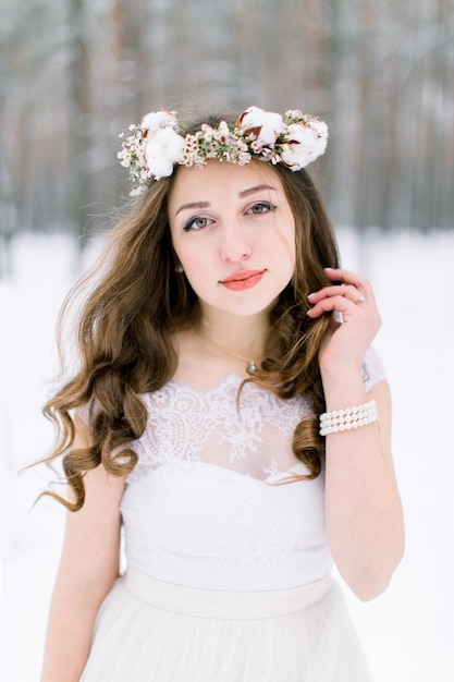 Hermosa joven novia en el bosque nevado de invierno