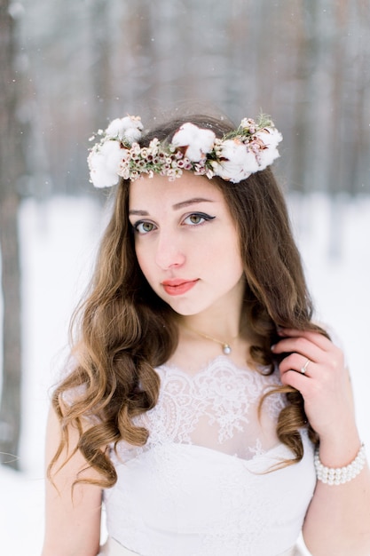 Hermosa joven novia en el bosque nevado de invierno